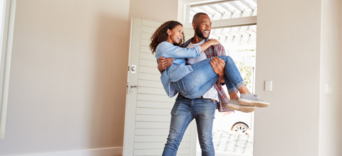 Young couple walking into their new home.